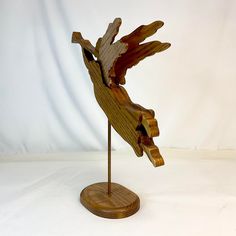 a wooden sculpture of a bird on a stand