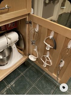 a kitchen cabinet with many attachments and mixers on the door handle in it