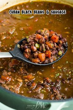 a spoon full of beans and sausage soup with the words cuban black beans and sausage