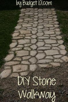 a stone path in the middle of a grassy area