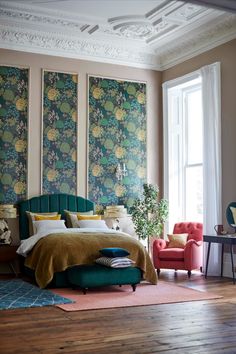 a bed room with a neatly made bed next to a large painting on the wall