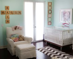 a baby's room with blue walls and white furniture