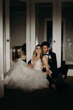 a bride and groom sitting on the floor