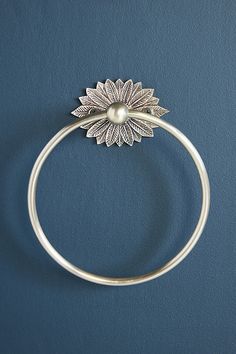 a close up of a ring with a flower on it and a pearl in the middle