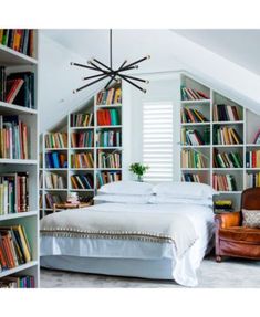 a bed sitting in a bedroom next to a book shelf filled with lots of books