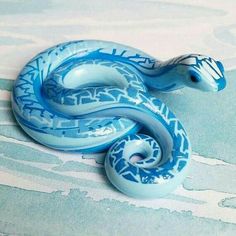 a blue and white snake figurine sitting on top of a tablecloth covered surface