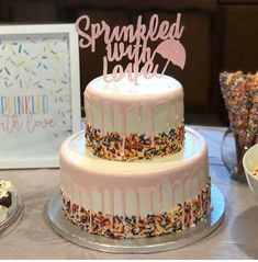 a birthday cake with sprinkles and a sign that says sprinkled with love