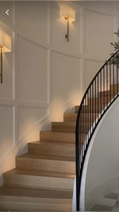 an elegant staircase with white walls and wooden steps