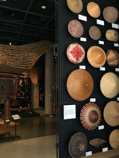 the wall is filled with many different types of hats on display in front of other items