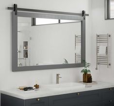 a bathroom with two sinks and a large mirror over the sink in front of it