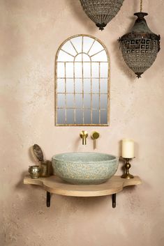 a bathroom sink sitting under a mirror next to a lamp and two hanging lights on the wall