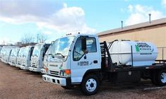 a row of white trucks parked next to each other in front of a warehouse building