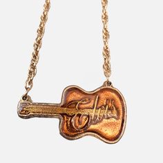 Vintage Elvis Presley "King of Rock" Guitar Pendant Necklace 24" Chain, Rare * Elvis Presley "King of Rock" guitar pendant necklace * Unique design capturing the essence of Elvis Presley * Vintage collectible from early 1977, originally created for concert sales * Limited production; scrapped after Elvis's passing * Chain length: 24 inches * Charm measures 3.5" x 2.5" * Gold-toned finish with a shiny Yellow inset on the guitar * Perfect for Elvis fans and collectors of music memorabilia * Great addition to any rock and roll or pop music collection * Vintage condition with minor wear due to age * Striking and sharp look, ideal for showing admiration for the King of Rock and Roll  This item has been in my late parents collection since they originally purchased it in the 70s. It was put in st Elvis Presley Jewelry, Elvis Merch, Cool Jewelry Unique, Elvis Jewelry, King Of Rock And Roll, Guitar Pendant, Rock Vintage, Rock Guitar, Necklace Unique