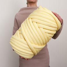 a woman holding a large yellow object in her hands