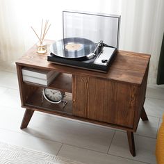 a record player and clock on a wooden table