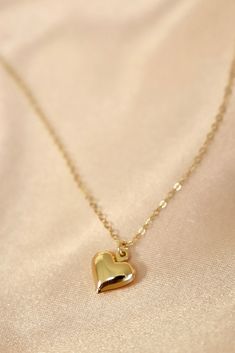 A brass puff heart charm on an 18" gold filled chain. Materials: gold filled chain, brass heart charm Length: 18" long SKU: CN1500G Elegant Gold Plated Heart Charm Necklace, Elegant Gold Charm Necklace With Heart Detail, Elegant Gold-tone Necklace With Heart Charm, 14k Gold-filled Heart Charm Necklace With Delicate Chain, Elegant 14k Gold-filled Heart Charm Necklace, Champagne Gold Dress, Puffed Heart, Gold Heart Necklace, Band Bracelet