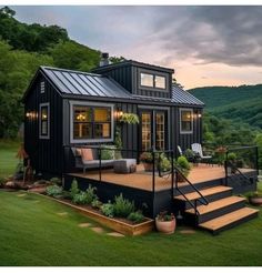 a small black house with stairs leading up to it