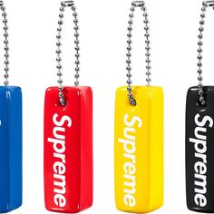 three different colored key chains with the word supreme on them, hanging from a ball chain