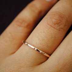 a woman's hand with a gold ring on her finger, showing the band