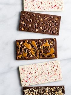 four different types of chocolates are lined up on a white counter top with sprinkles