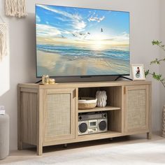 a flat screen tv sitting on top of a wooden entertainment center in a living room