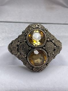 "This is a beautiful vintage Theodor Fahrner sterling silver and golden topaz ring.  The marks on the ring are harder to decipher as the ring has been sized down with sizing balls soldered to the band but its \"TF\" in a circle mark is still visible as well as \"ER\" of Fahrner.  The ring is in very good vintage condition, there is some surface wear, a couple scratches, and small flea bites to the golden topaz stones, wear to the filigree on the sides of the ring, and there also appears to be an area on the back of the band where we think it was rubbed or tested for silver purity.  The ring is a size 7 and the ring weighs approximately 7.58 grams. - For international customers, please note that customs or duty fees are the buyer's responsibility and are not included in the price." Antique Adjustable Rings With Intricate Design, Vintage Sterling Silver Topaz Collectible Ring, Antique Finish Anniversary Jewelry Ring, Vintage Stamped 925 Topaz Ring Gift, Antique Silver Engraved Ring, Antique Silver Open Signet Ring, Vintage Sterling Silver Engraved Dome Ring, Silver Antique Signet Ring, Antique Silver Engraved Ring With Oxidized Finish For Anniversary