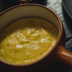 a bowl of soup sitting on top of a wooden table