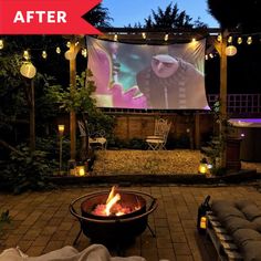 an outdoor movie screen is lit up in the evening with candles and blankets around it