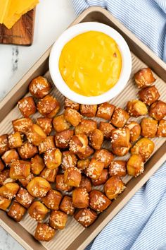 a tray filled with tater tots next to a bowl of mustard