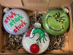 three christmas ornament ornaments in a box with the words stink st nick on them