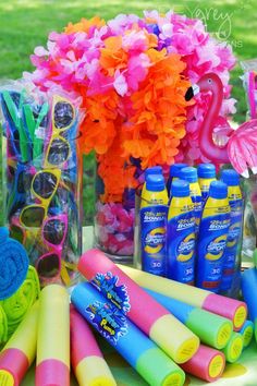 there are many items on the table for sale at this party, including sunglasses and flowers