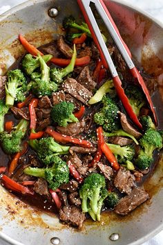 beef and broccoli stir fry in a pan with chopsticks