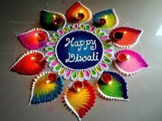 colorful diya with happy diwali written in the center and lit candles on top