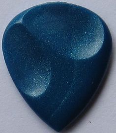 a blue guitar pick sitting on top of a white table