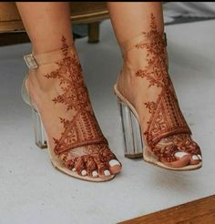 a woman's feet with henna tattoos on them