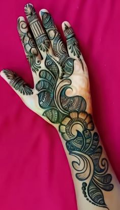 a woman's hand with henna tattoos on her left arm and the top half of her body