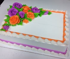 a white cake with orange and purple flowers on it