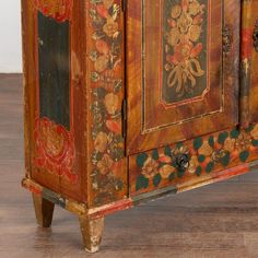 an old wooden cabinet painted with floral designs