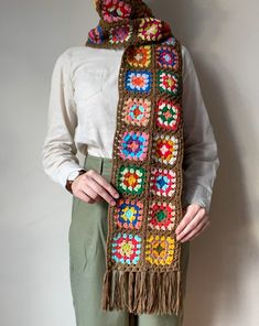 a woman wearing a crocheted scarf with flowers on it