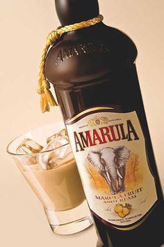 a bottle of amarula next to two glasses filled with ice