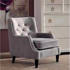 a white dresser and chair in a room with purple walls, drawers and artwork on the wall