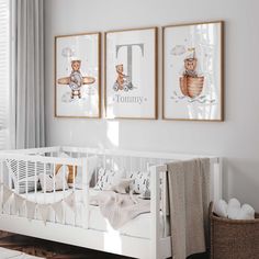 a baby's room with two framed pictures on the wall and a crib