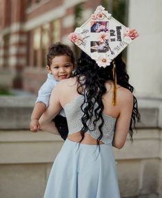 a woman holding a baby wearing a graduation cap