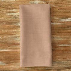 a folded napkin on top of a wooden table