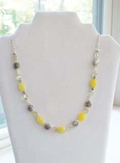 This beautiful necklace is made with 10 mm faceted oval yellow jade, oval nugget yellow quartz, tiny faceted yellow jade spacer beads, 3 mm round white moonstone, and pewter spacer beads. This is a very dainty necklace. It has a lot of charm and would match almost anything.  Gemstones- Yellow Jade, Yellow Quartz, Moonstone Length- 20 inches overall, 12 inches beading and 8 inches beading Jade is said to bring luck, long life, and friendship. Quartz is is calming and peaceful and may help boost the immune system.  Moonstone may bring balance and harmony. Chakra- Solar Plexis; confidence, charisma, adaptability, leadership Because these are natural semi-precious gemstones, each stone is unique in color, and can even vary slightly in size and shape. However, all stones are very similar to the Yellow Beaded Necklaces With Faceted Beads For Gift, Yellow Gemstone Beaded Necklaces, Adjustable Yellow Oval Beaded Jewelry, Yellow Faceted Beads Beaded Necklace, Yellow Jewelry With Polished Oval Beads, Yellow Faceted Beaded Necklaces, Yellow Necklace With Faceted Beads, Yellow Oval Polished Bead Jewelry, Yellow Quartz