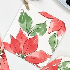 watercolor poinsettis on white paper next to scissors