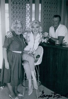 an old black and white photo of two women sitting at a bar with a man standing behind them