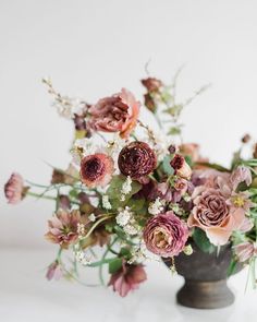 a vase filled with lots of flowers on top of a table