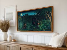 a painting hanging on the wall next to a wooden cabinet with vases and plants