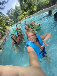 a group of people in the water with life vests on and one person holding out their hand